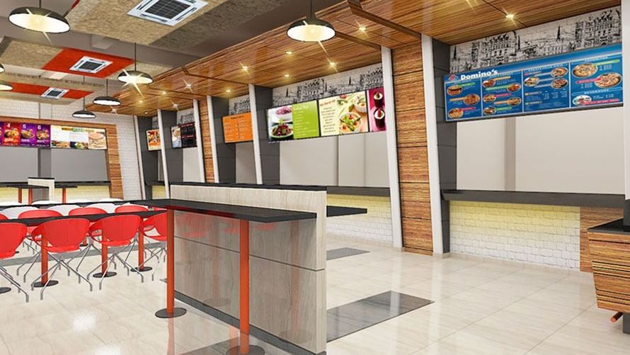 Dining area with red chairs, tables and colorful wall decor at Max Hotel Prayagraj.