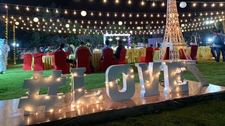Night-time event setup with decorative lighting and LOVE sign on the lawn at Ilara Hotels & Spa, OMR, Chennai