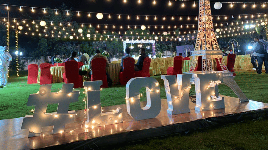 Night-time event setup with decorative lighting and LOVE sign on the lawn at Ilara Hotels & Spa, OMR, Chennai