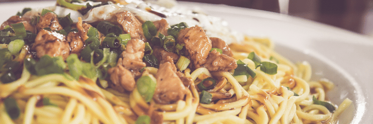 A delicious plate of noodles topped with vegetables and chicken served fresh at a popular restaurant in Varanasi - Hotel Uday Palace.