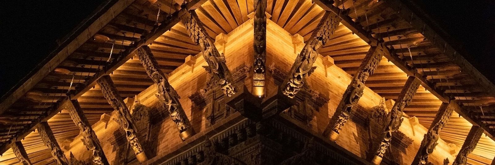 The carvings on a temple structure which is brightly lit