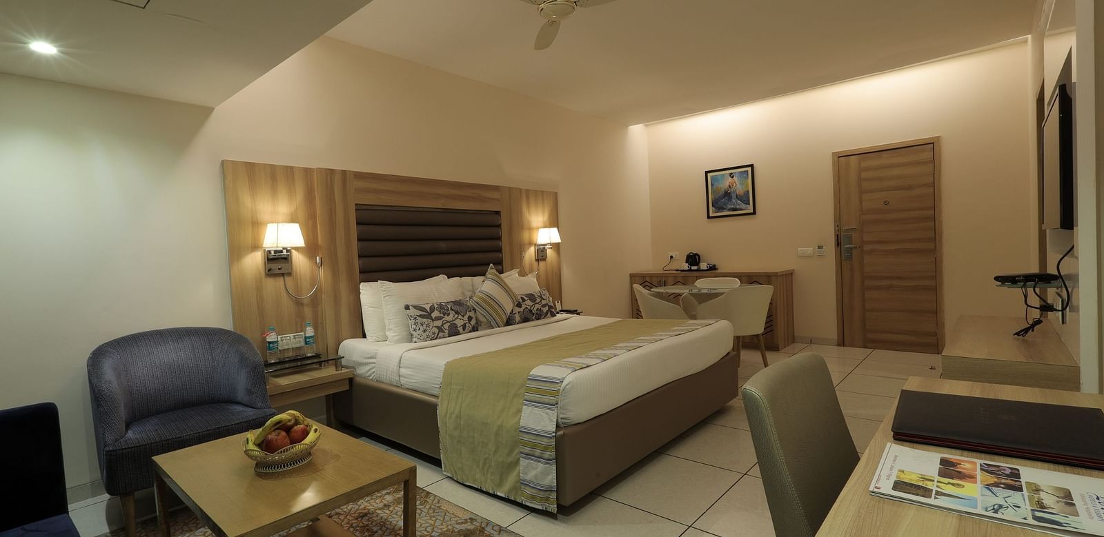 A hotel room at Rang Lords Inn, with a view of the bed and a partial view of the bathroom, displaying the room's layout and amenities