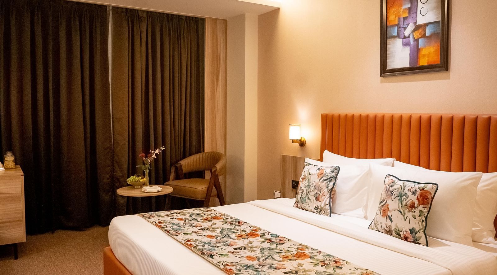 Superior Room at ASTER GRAND BY ZENQ SAKET with a bed, bed side table, a chair and a window with curtain in the background.