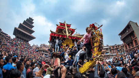 Energetic devotees pulling the massive wooden chariot during Newari cultural festival celebrations in historic Bhaktapur, Nepal.