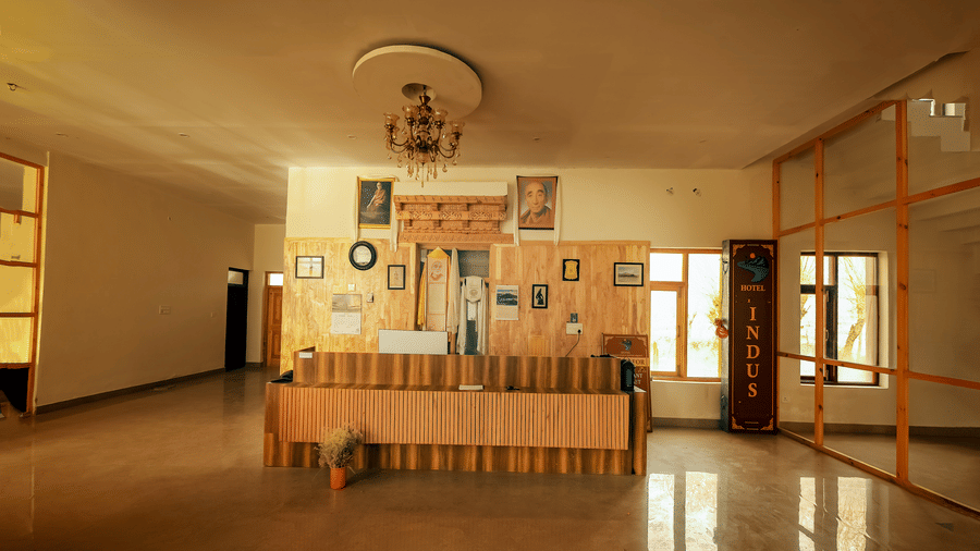 A wide interior view of the wooden reception desk and spacious lobby at Indus Serenity Retreat.