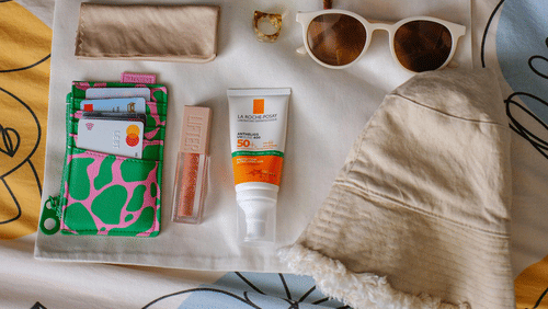 A tote bag with various travel essentials placed on it.