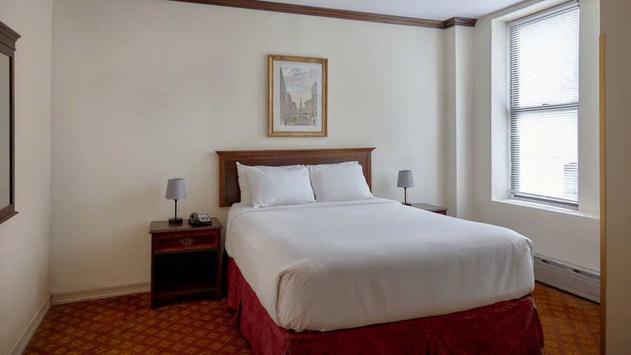 Room at Night Hotel Broadway showing a bed, framed wall art, and window near the corner.