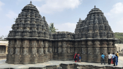 people standing under a temple under blue skies