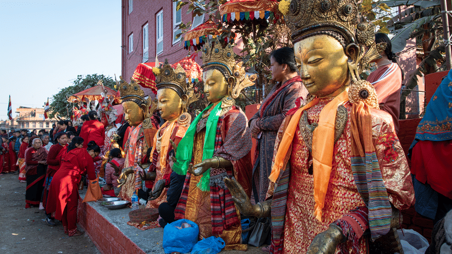 Row of sacred golden Dipankara Buddha statues displayed during a traditional Newar Buddhist festival in Kathmandu Valley, Nepal.