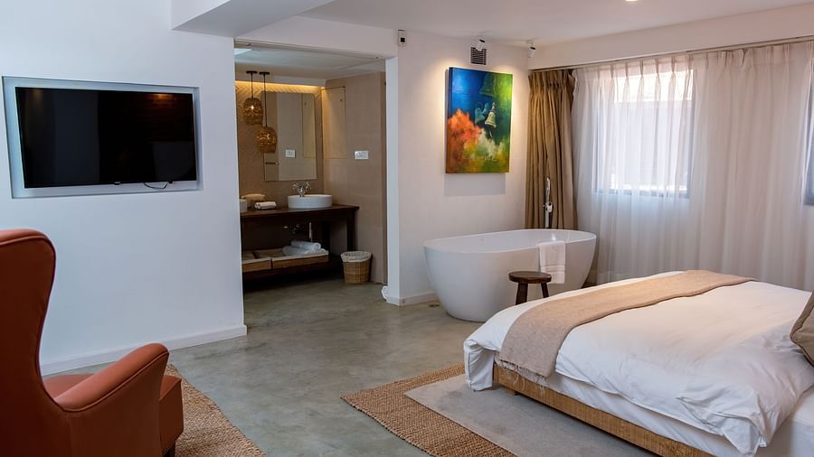 The Nepali Suite featuring a bed, flat screen TV, a sofa and a bathtub - The Nanee