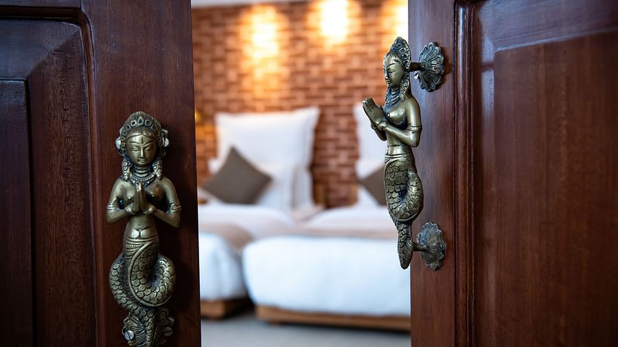 A partially open door with brass handles leads into a room at The Nanee.