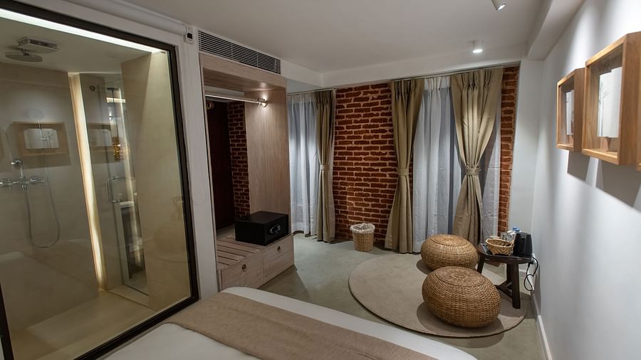 Standard room with bed, bamboo tools and a away leading to the washroom - The Nanee 