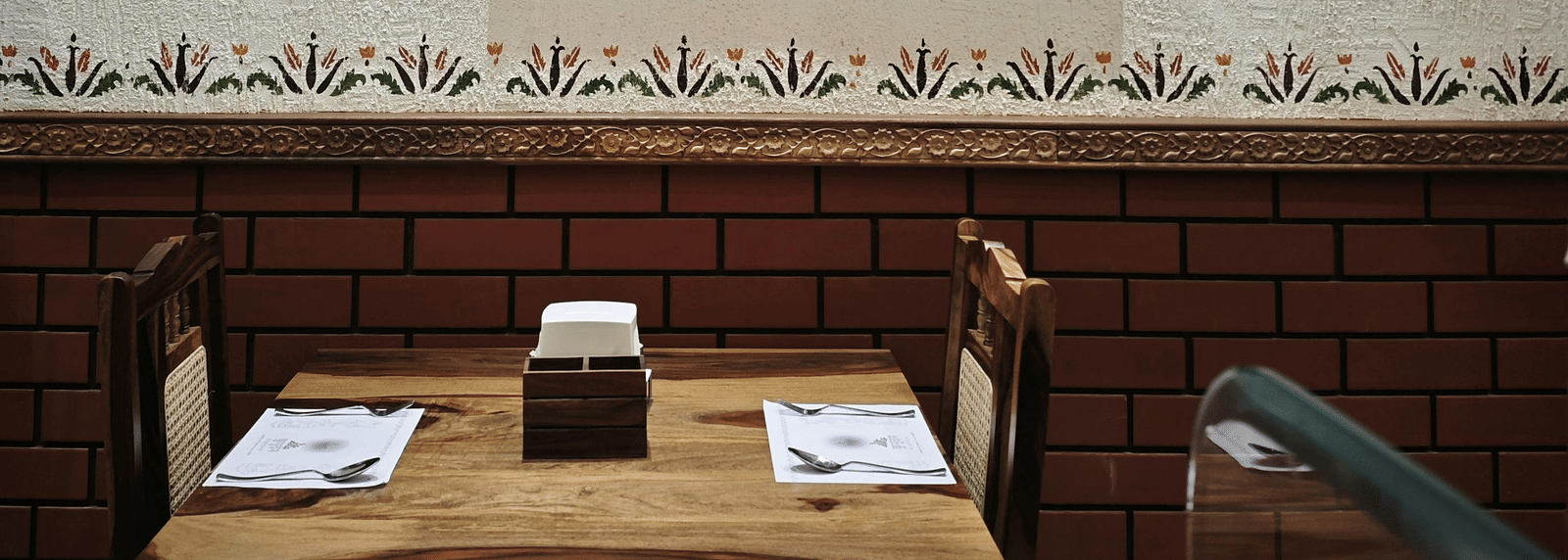 Close-up of a framed artwork hanging above a wooden dining area.