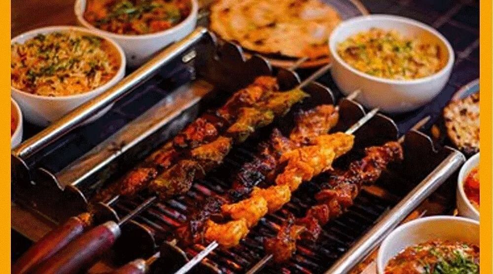 Am image of a barbecue grill with several dishes served around it in a bowl - Themis Barbecue House