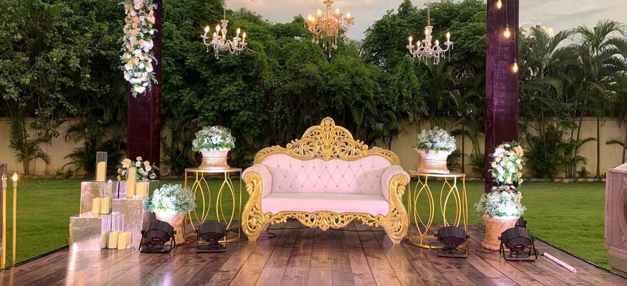 Ornate outdoor stage adorned with flowers and chandelier lighting at Ilara Hotels & Spa, OMR, Chennai