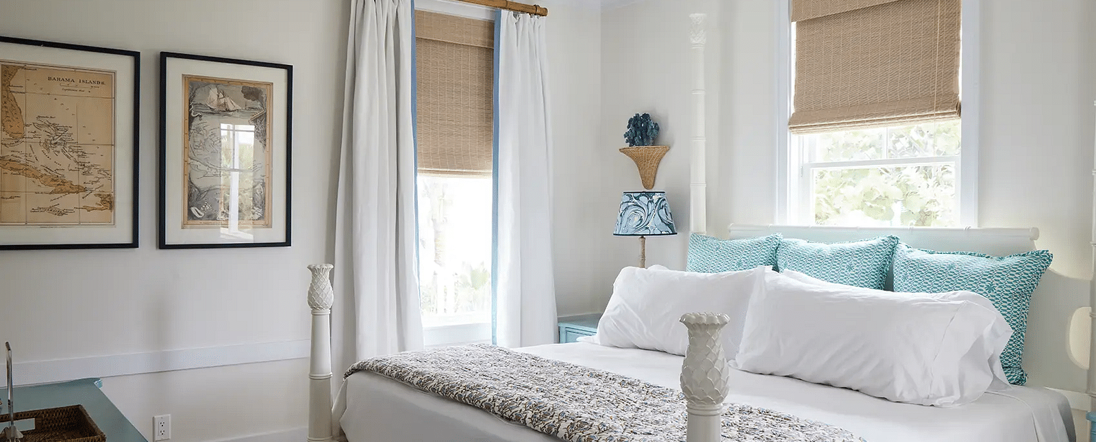 Bright bedroom with a four-poster bed, framed art, and a ceiling fan | Abaco Inn