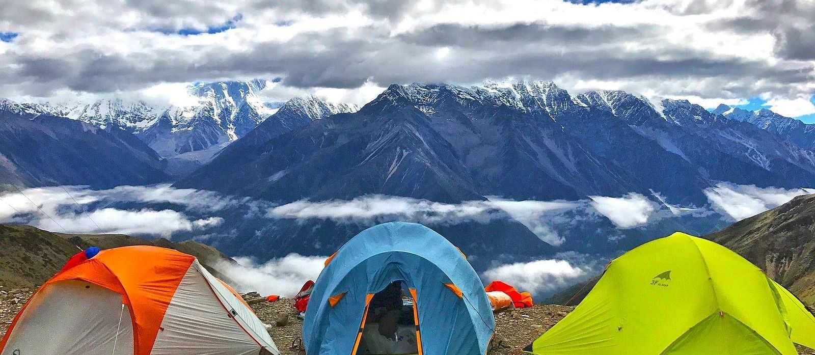 camping tents overlooking snow-capped mountains