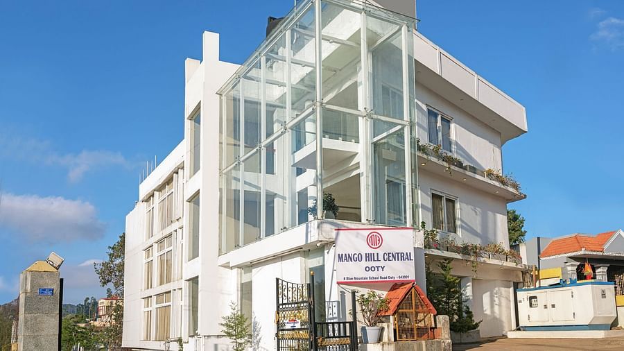 Exterior view of a contemporary white building with glass balconies | Mango HIll Central, Ooty