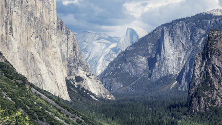 A valley at Yosemite National Park with snow-capped mountains in view.