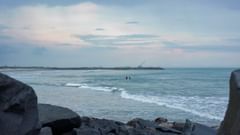 Boulders next to a beach in Tranquebar with waves lapping