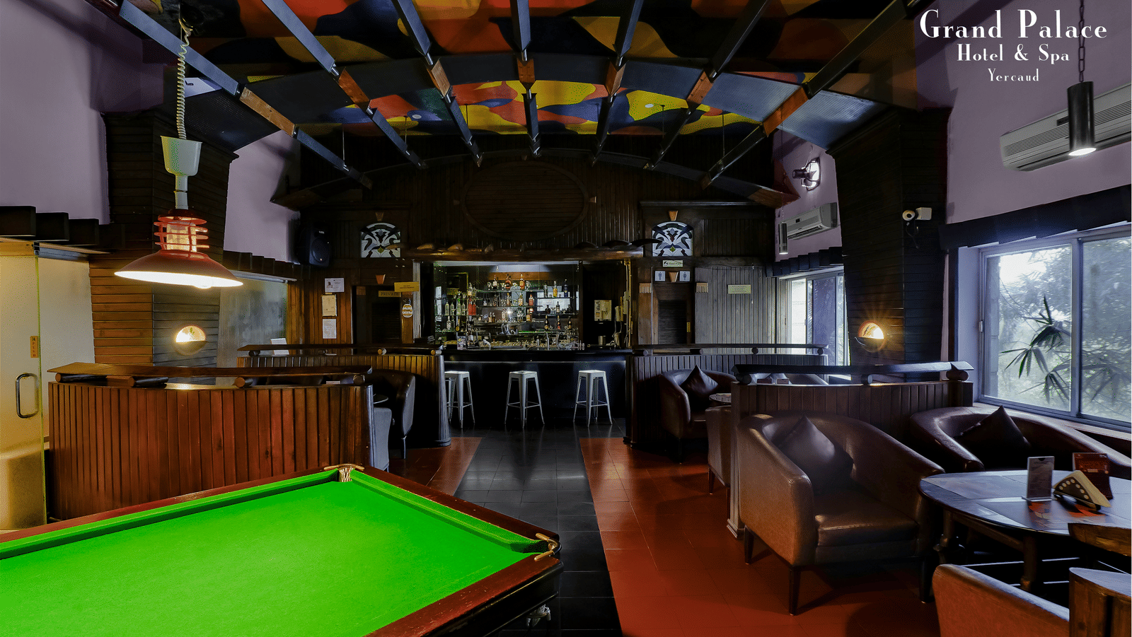 Interior view of Cloud-9 Bar at Grand Palace, Yercaud with billiards table, wooden ceiling, and seating booths.