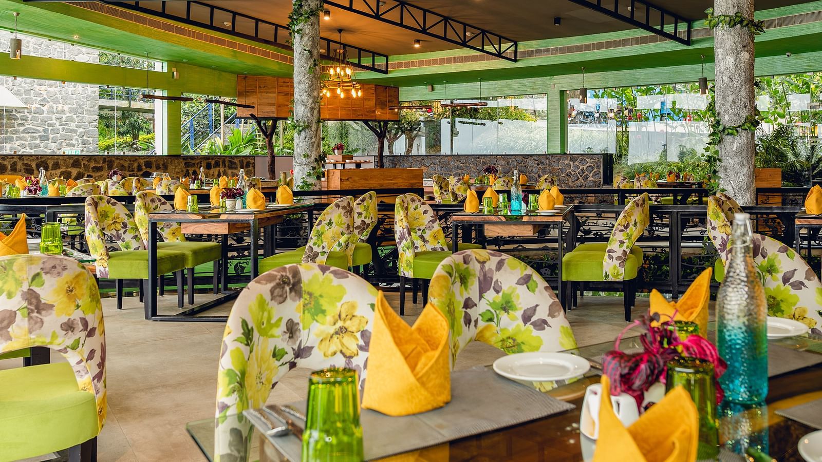 An image of a restaurant with different seating arrangement, bright lighting, and decorative items - Great Trails Yercaud by GRT Hotels