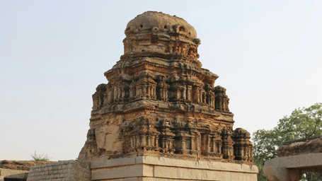 A temple with intricate carvings of idols on the outer wall