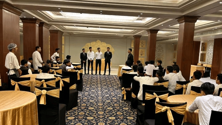 An overview of a hall filled with tables and chairs during a function at Clarks Group of Hotels. Guests sit around the room.