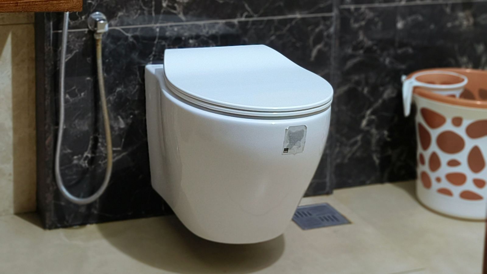 Front view of a W/C with a bucket on side in the washroom at 102 room at Ananda Holiday Home, Wayanad 3