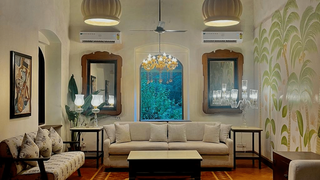 An image of a living area with sofas and centre tables, photo frames on the wall, tables on each corners where decorative items are placed - Lamrin Ucassaim Hotel, Goa