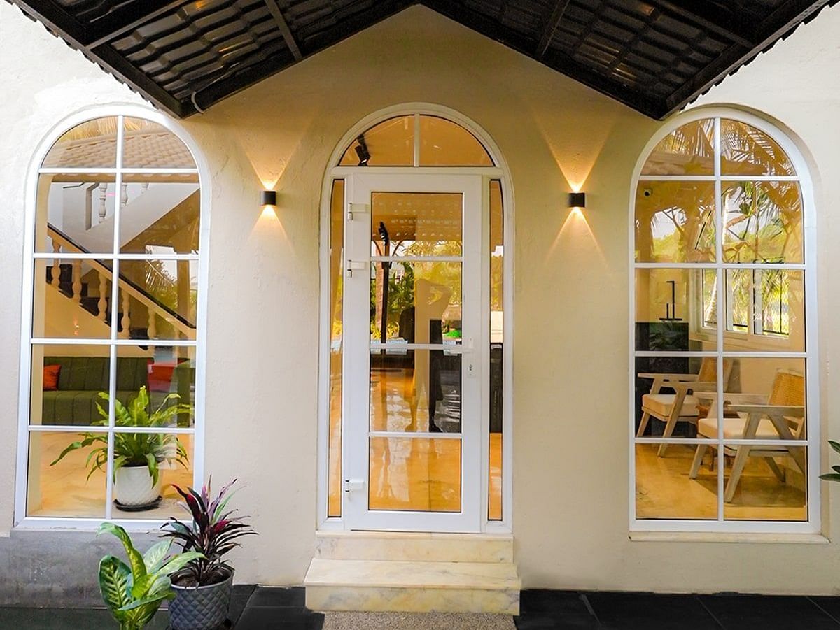 A brightly lit entrance to a building with white walls and arched doorways and windows at Kssemya