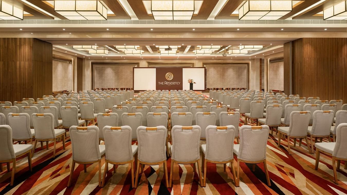 Banquet hall with a theater-style seating arrangement and a stage at The Residency Towers Coimbatore