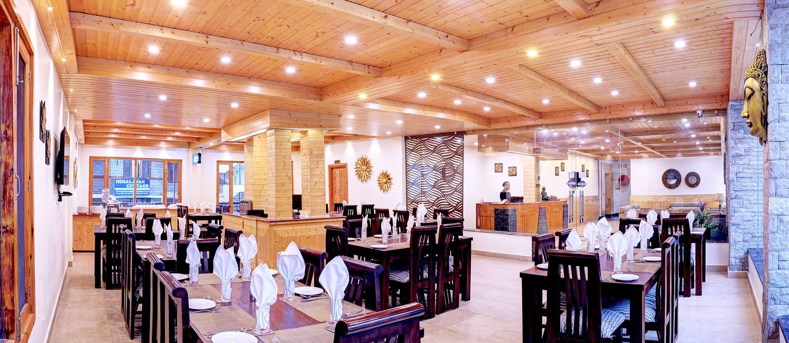 Image of a restaurant with tables and chairs and wooden ceiling at Summit Chandertal Regency Hotel & Spa