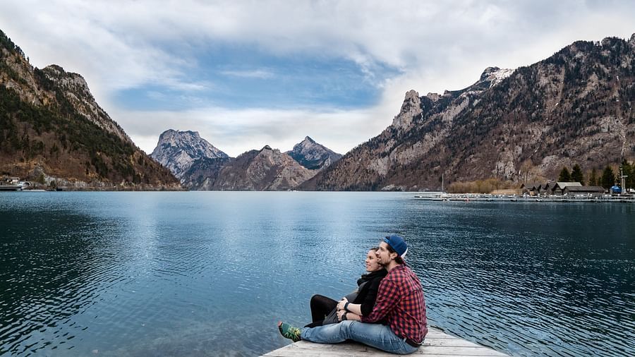 A couple seated by the lake
