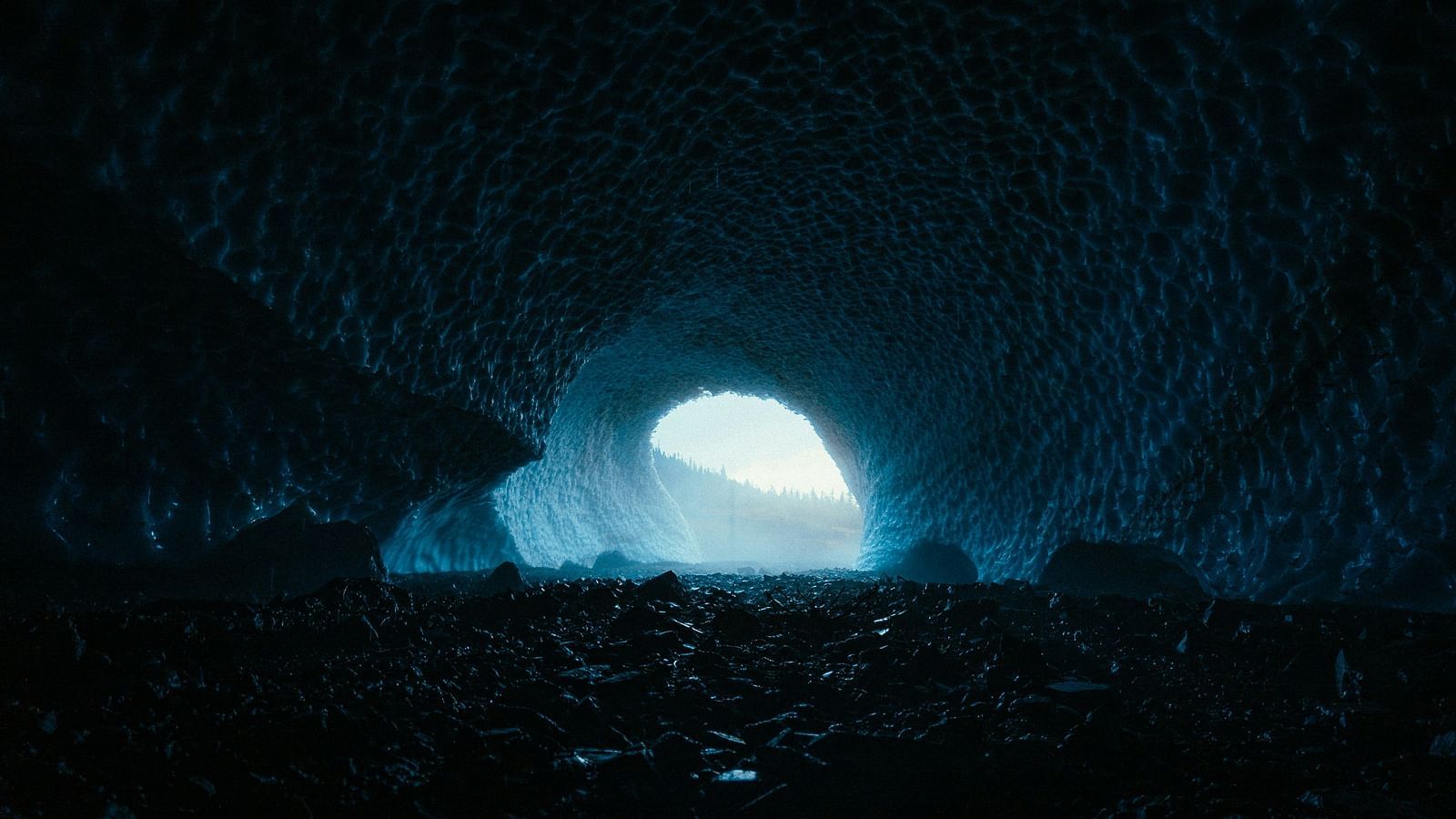 A view from inside a cave of the opening with the light showing
