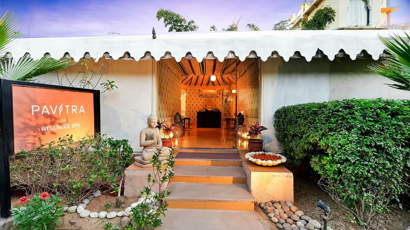 Entrance to a tent with potted plants on either side and twilight sky above - Rajasthali Resort & Spa, Jaipur.