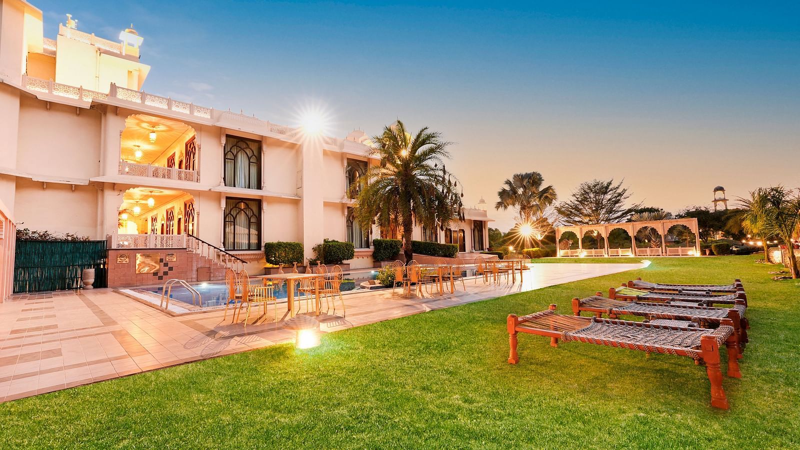 Lawn are with a sit out in front of the building in the night - Rajasthali Resort & Spa, Jaipur.