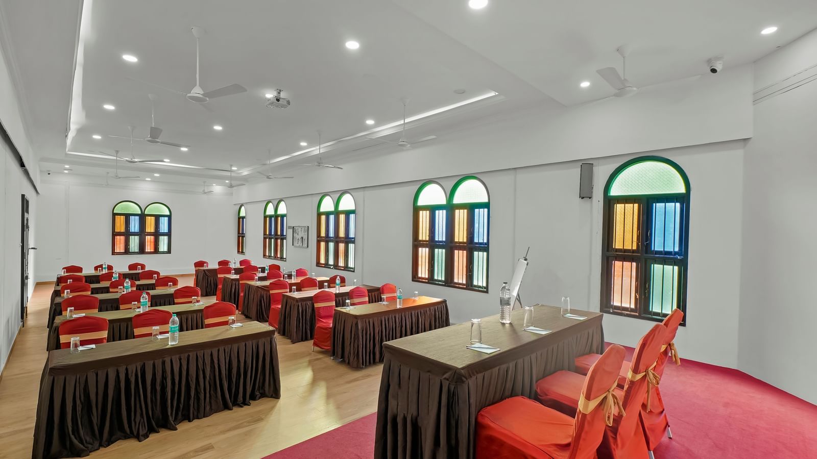 Diagonal view of a banquet hall with tables and chairs arranged for an event at WOW Bungalow, Yercaud.