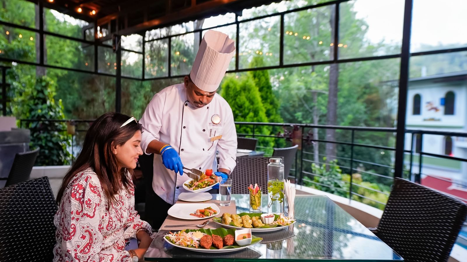 A chef serving food to a lady at WOW Bungalow, Yercaud.