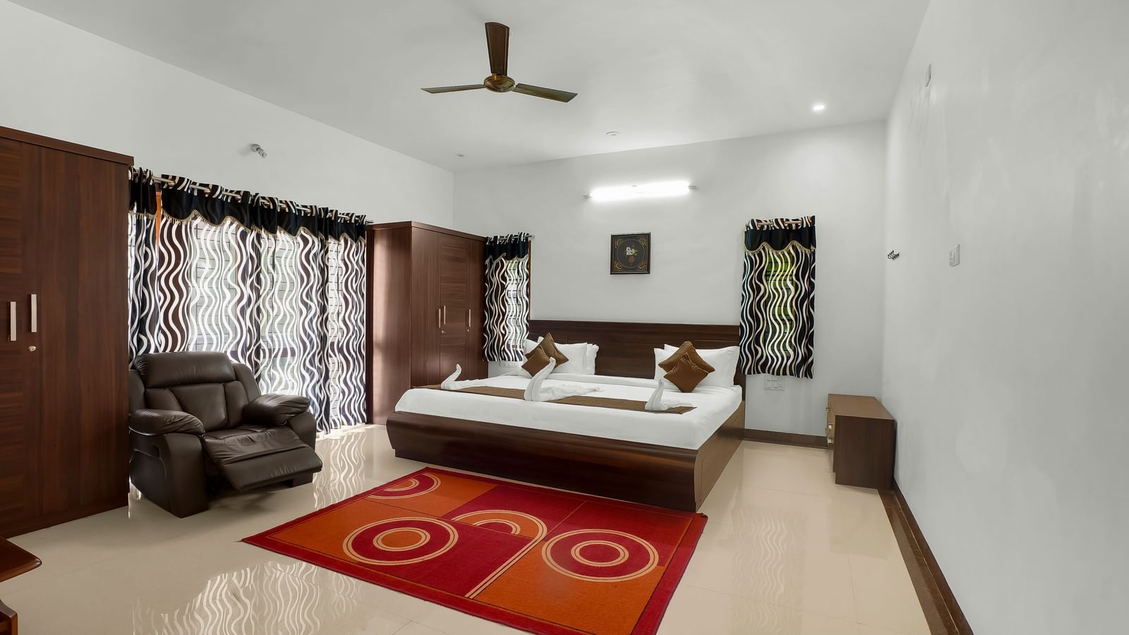 A spacious bedroom with a large bed and wooden furnishings at WOW Bungalow, Yercaud.