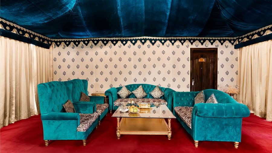 An overview of the living area inside a tent with sofas and a coffee table - Rajasthali Resort & Spa, Jaipur.