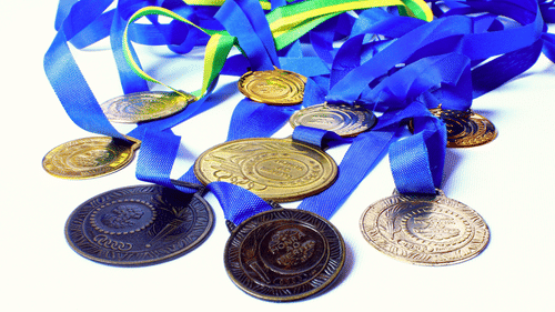 A close up shot of many medals of different colours kept on a table.