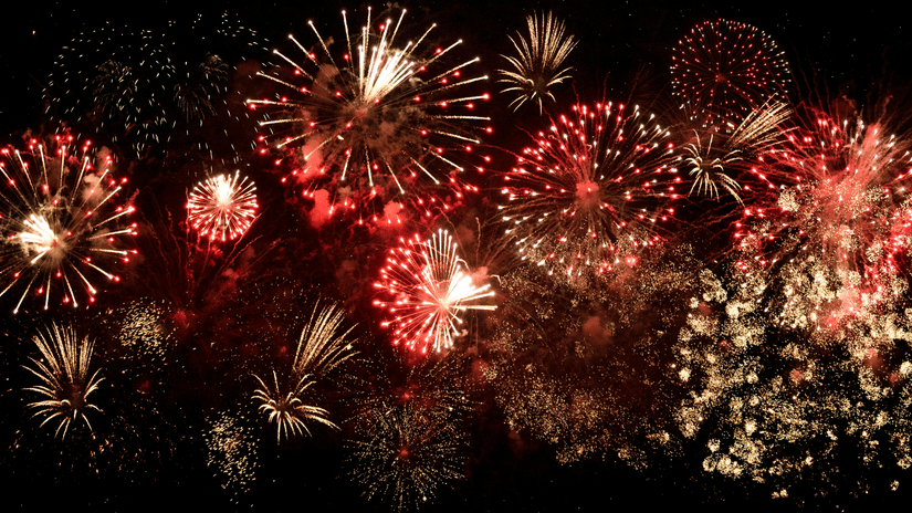 A night sky filled with red and gold fireworks bursting in various patterns | HHI Varanasi