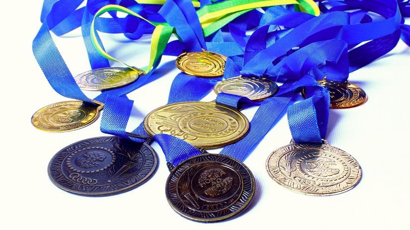 A close up shot of many medals of different colours kept on a table.