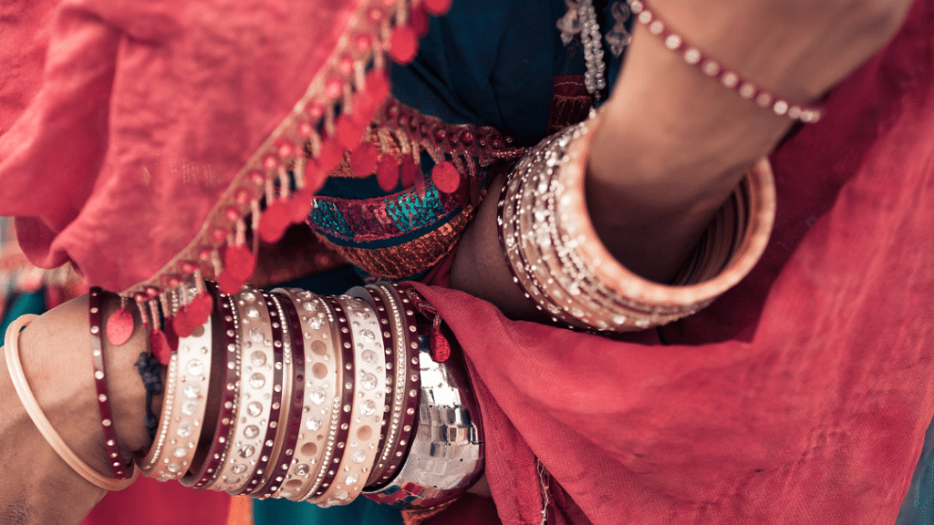 A close up shot of a woman wearing bangles and traditional Rajasthani attire