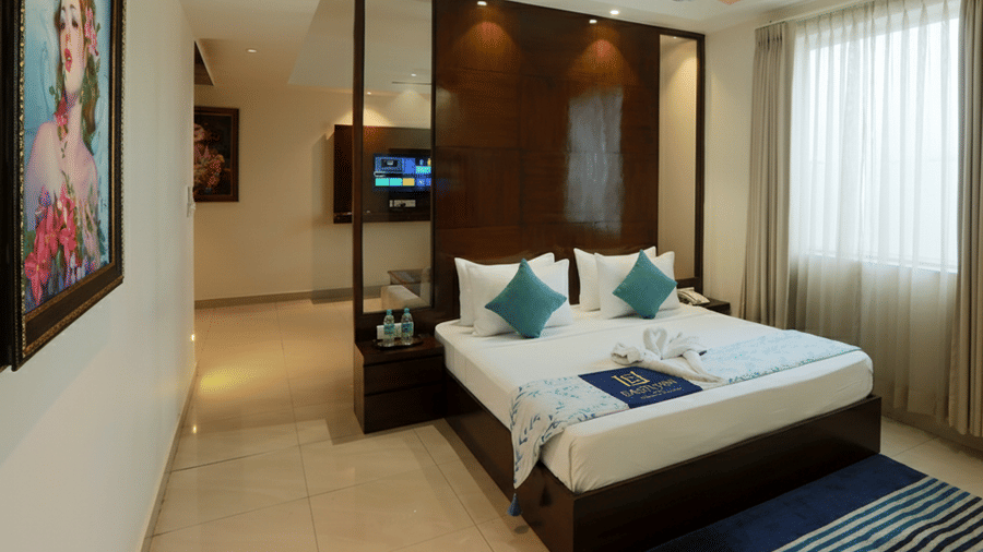 An executive suite showing a partitioned sleeping area with a king bed and a polished tile floor corridor — Eastlynn Resort, Rishikesh