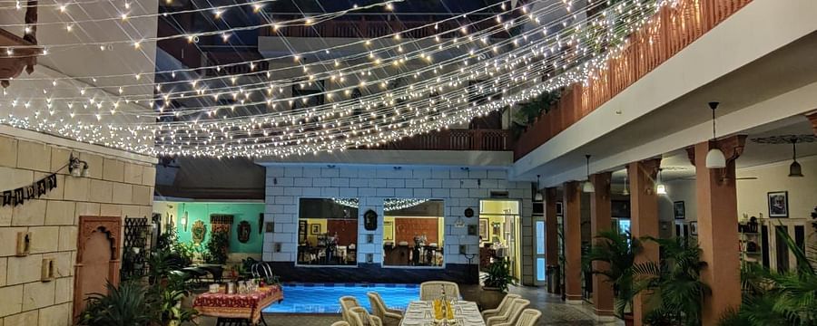 Seating arrangement with fairy lights on the top at Al-fresco Dinner at the courtyard at Suryaa Villa Jaipur