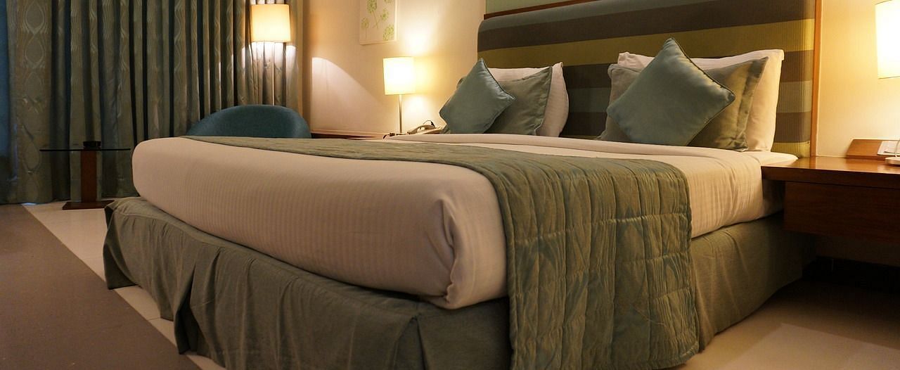Image of a bedroom with a large bed, side tables, and lamps.