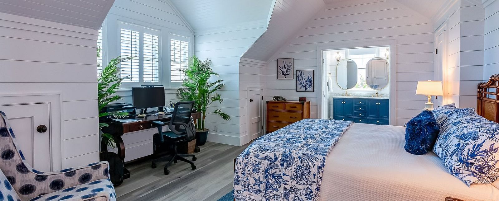 Spacious bedroom with a wooden bed, blue accents, and a ceiling fan | Abaco Inn