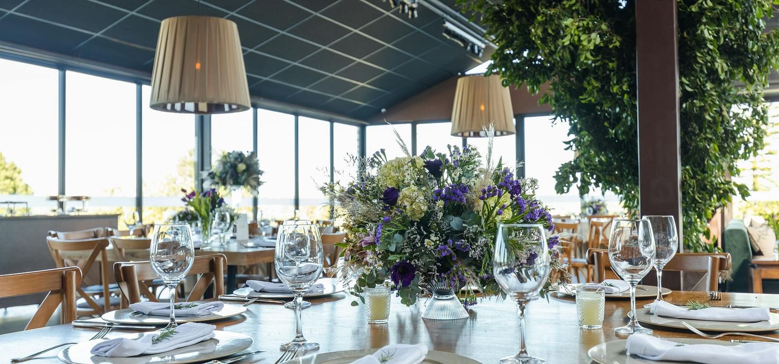 Banquet hall with cutley on the table and lights hamging from the ceiling